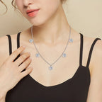 Woman wearing a silver necklace with diamond-like stones on a beige background