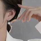 Close-up of a person wearing a diamond earring with a blurred background