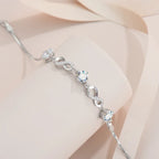 Silver bracelet with diamond-like stones on a soft beige fabric background