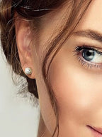 Close-up of a woman wearing a diamond stud earring with a blurred background