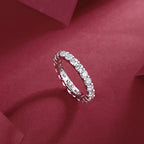 Silver ring with diamonds on a red fabric background