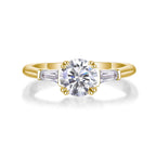 Gold ring with a central diamond and two smaller diamonds on a white background