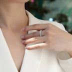 Close-up of a hand wearing a diamond ring on a blurred background