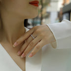 Close-up of a hand wearing a silver ring with a blurred background