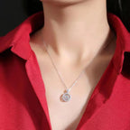 Necklace with a pendant worn by a person in a red shirt against a dark background