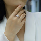 Hand wearing a diamond ring with a blurred background