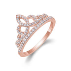 Rose gold tiara-shaped ring with diamonds on a white background