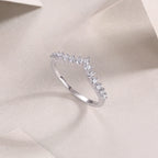 Silver ring with small diamonds on a soft beige fabric background