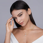 Woman wearing gold necklaces with a gray background