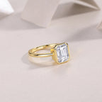 Gold ring with a large diamond on a soft beige background