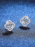 Pair of silver earrings with gemstones on a blue textured background