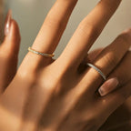 Close-up of a hand wearing two rings with a blurred background