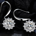 Silver earrings with snowflake-shaped crystals on a dark background