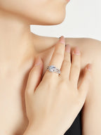 Close-up of a hand wearing a diamond ring on a neutral background