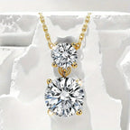 Gold necklace with two round diamonds on a white stone background
