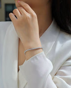 Close-up of a person wearing a silver bracelet on a white background