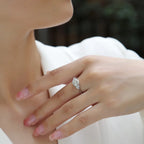 Close-up of a hand wearing a diamond ring with a blurred background