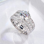 Silver ring with a large central gemstone and smaller stones on a white background