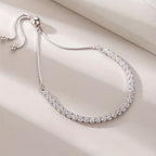 Silver necklace with clear stones on a light beige surface