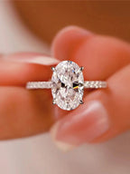 Diamond ring held between fingers with a blurred background