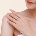 Close-up of a hand wearing a diamond ring on a beige background