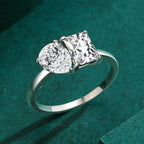 Silver ring with two diamonds on a green textured background