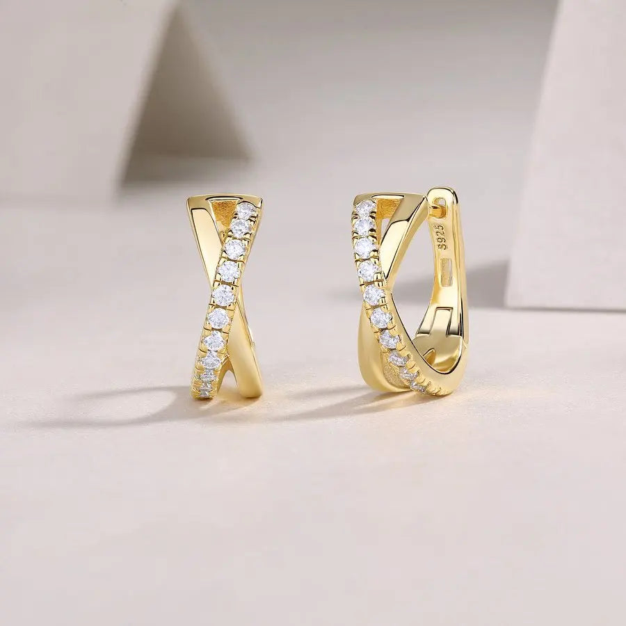 Gold hoop earrings with embedded diamonds on a light background