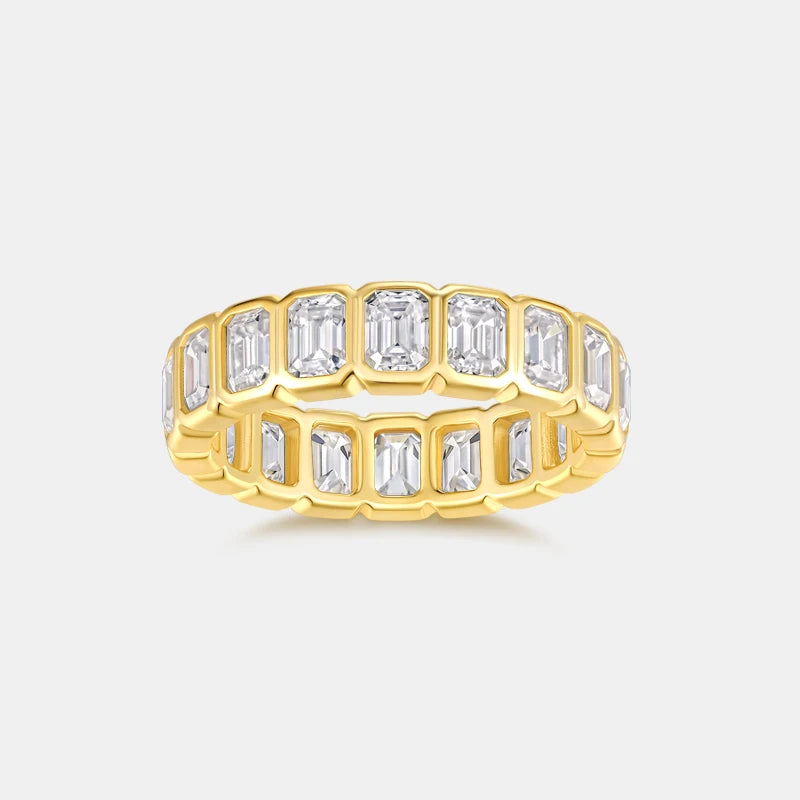 Gold ring with emerald-cut diamonds on a light gray background