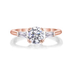 Rose gold ring with a large diamond and smaller gemstones on a white background