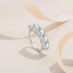 Silver ring with clear gemstones on a soft pink background