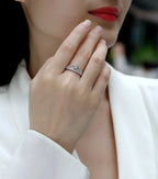 Close-up of a hand wearing a diamond ring with a blurred background