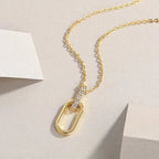 Gold necklace with a unique pendant on a beige background