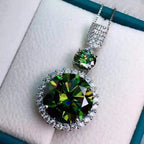 Green gemstone pendant with diamond accents on a white background