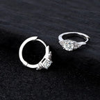 Two silver hoop earrings with gemstones on a black background