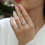 Close-up of a hand wearing a diamond ring with a blurred background