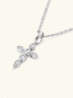 Silver cross-shaped pendant necklace with clear stones on a white background