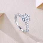 Silver ring with a large diamond on a light pink background