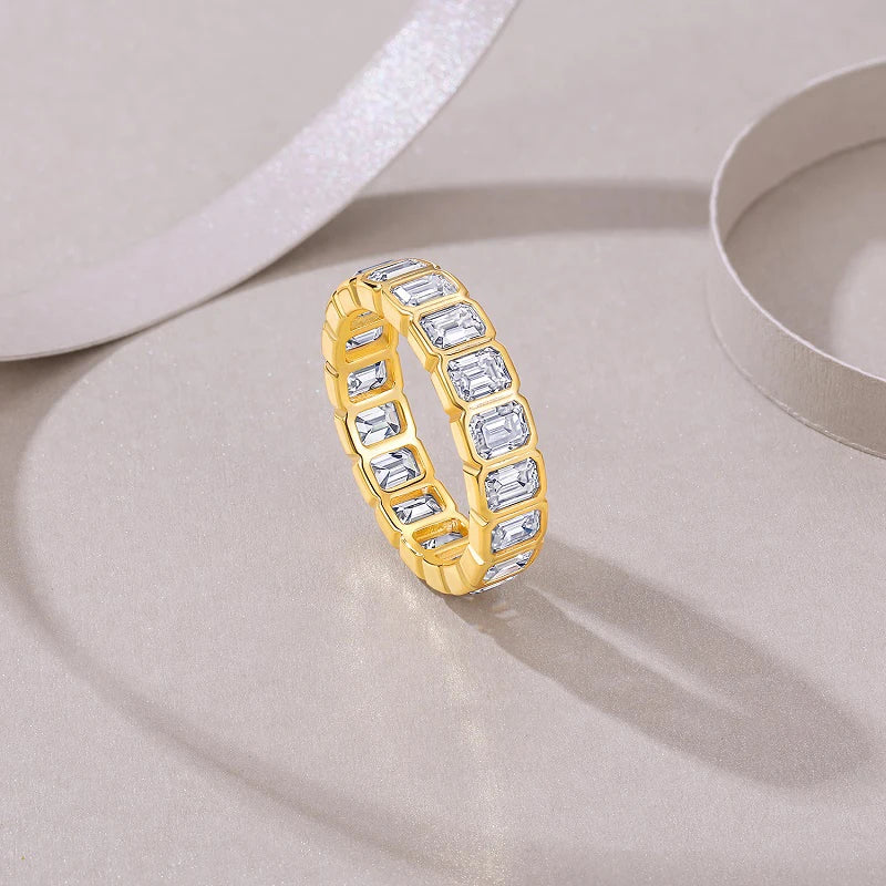Gold ring with diamond accents on a light gray surface