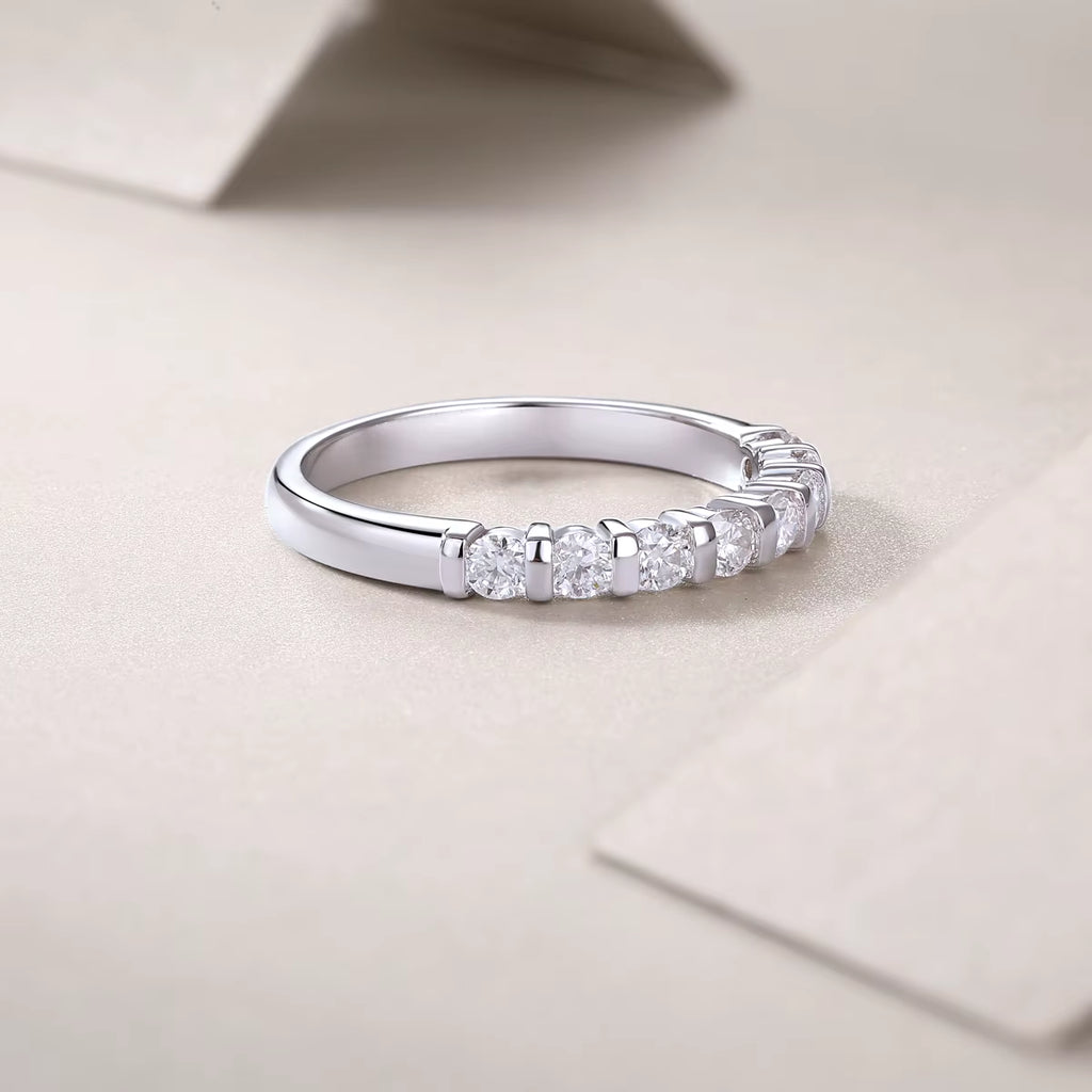 Silver ring with diamonds on a beige surface