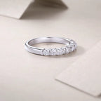 Silver ring with diamonds on a beige surface