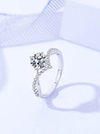 Silver ring with a large central gemstone on a light blue background