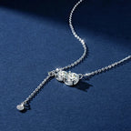 Silver necklace with a heart-shaped pendant on a blue background