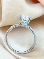 Silver ring with a large diamond on a beige fabric background