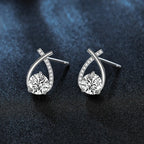 Silver earrings with round gemstones on a dark textured background