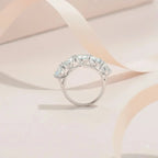Silver ring with gemstones on a soft pink background